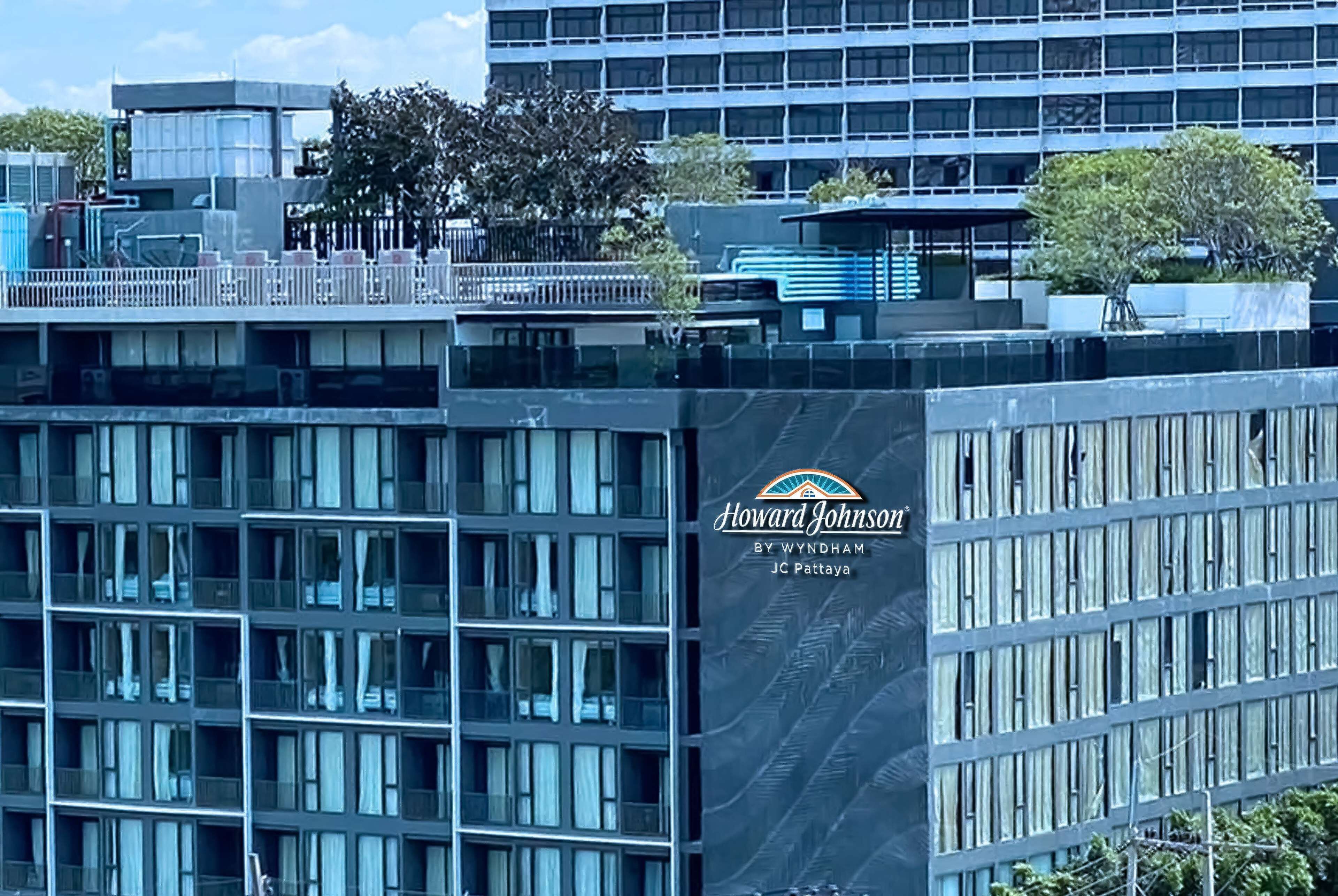 Ein modernes Gebäude mit einem gut sichtbaren "Howard Johnson"-Schild, das ein Logo und die Namen von Designern zeigt.