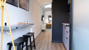 Une cuisine moderne dotée d’un plan de travail en bois, d’un four encastré et d’une armoire de couleur sombre.