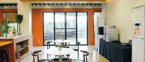 Una cocina moderna con techo de madera, ventanas amplias y un comedor con mesa y sillas redondas.
