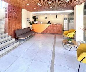 Una moderna zona de recepción con techo de madera, un mostrador de recepción, un sofá y sillas amarillas.