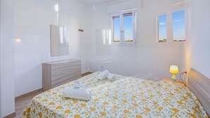 A bedroom with a bed, bedside lamp, window, and a mirror. - Le Bianche Apt 3 - terrace near the Sea, Manduria, Italy (Manduria)