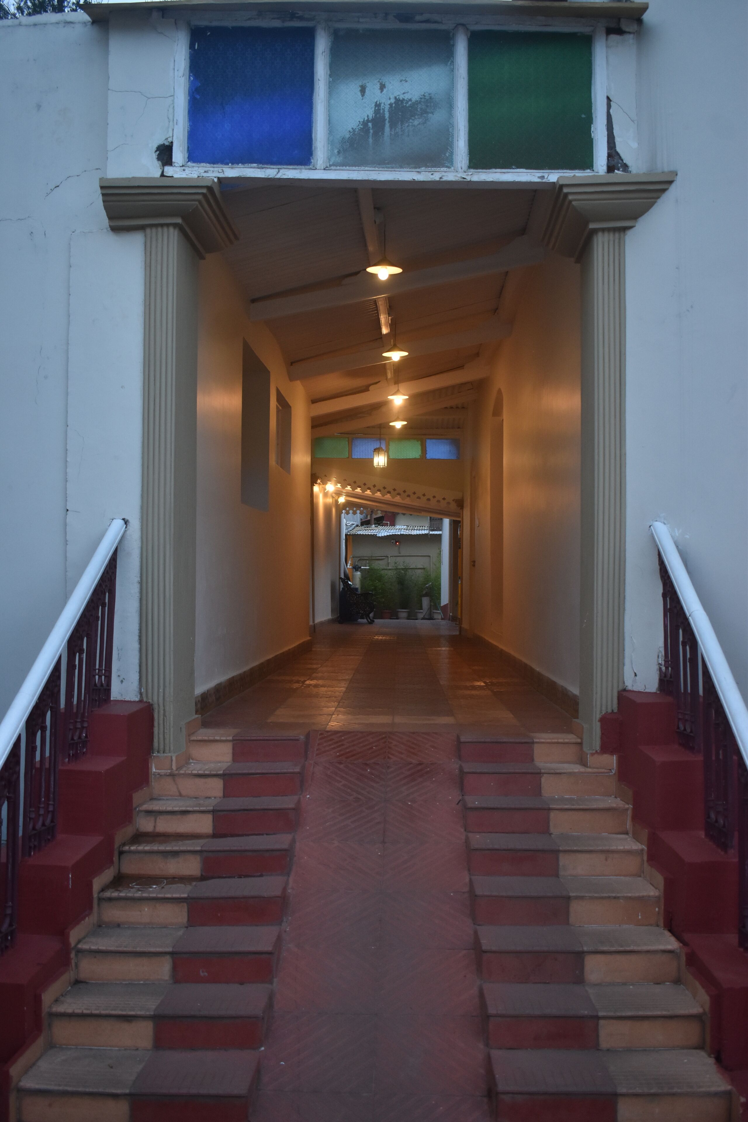 A staircase with alternating red and beige steps leading to a doorway.