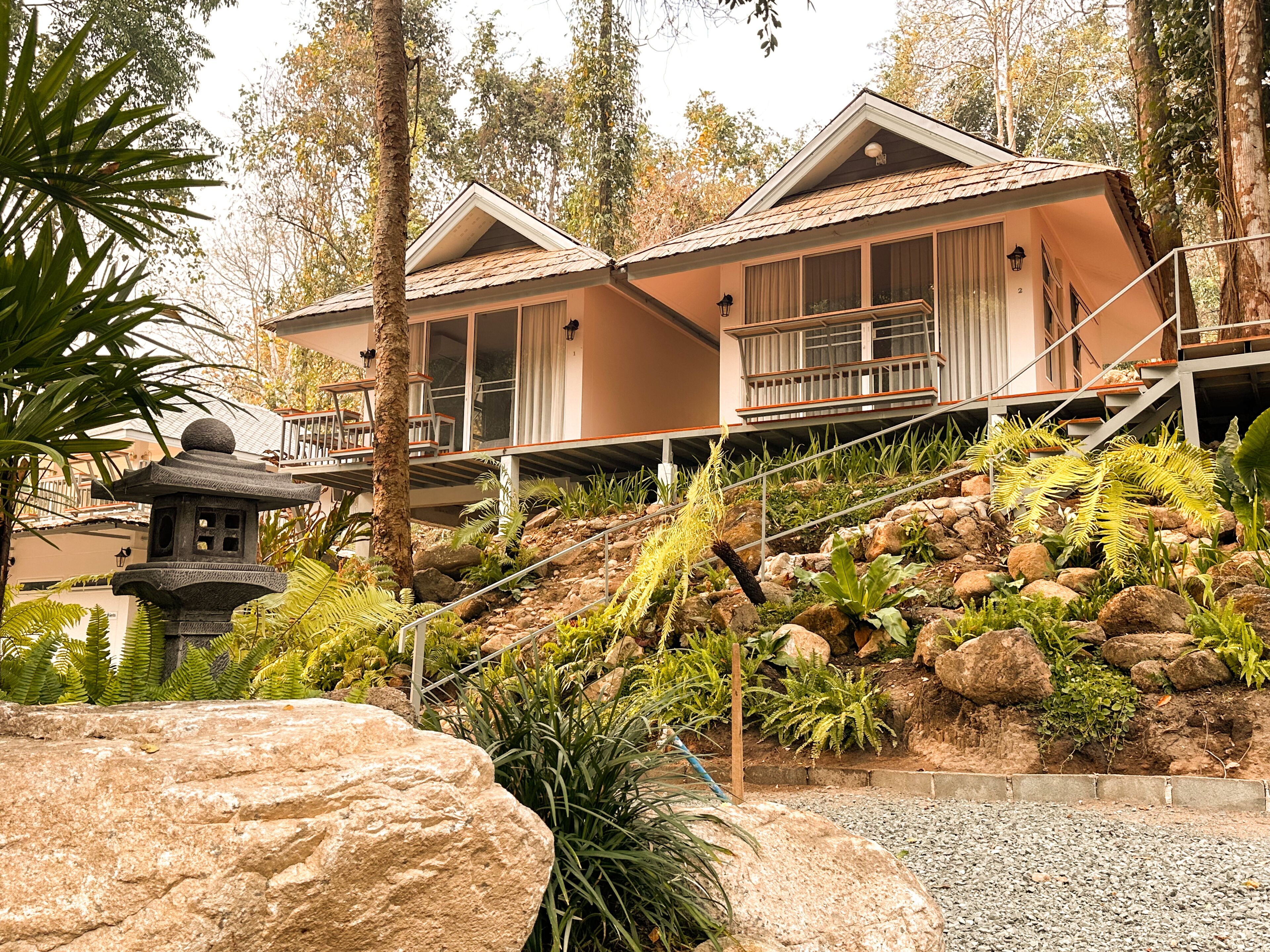 A two-story house with a stone staircase leading to a balcony.
