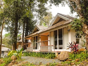 A house with a porch, large windows, and a garden with rocks and plants. - Arb Pa Home & Cafe Chiang Mai (Mae On)