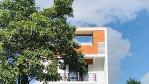 A modern hotel with a booking office, a visible phone number, and a signboard. - Nam Anh Hotel (Phong Nha)