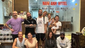 A group of people posing in front of a hotel named "NAM ANH HOTEL". - Nam Anh Hotel (Phong Nha)