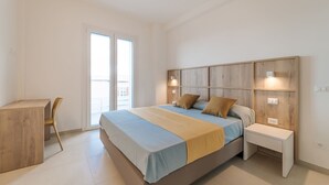 A modern bedroom with a large bed, bedside tables, a desk, and a chair. - RESIDENCE PADULELLA - 7 - RESIDENCE PADULELLA - APP A PIANO 1 (Portoferraio)