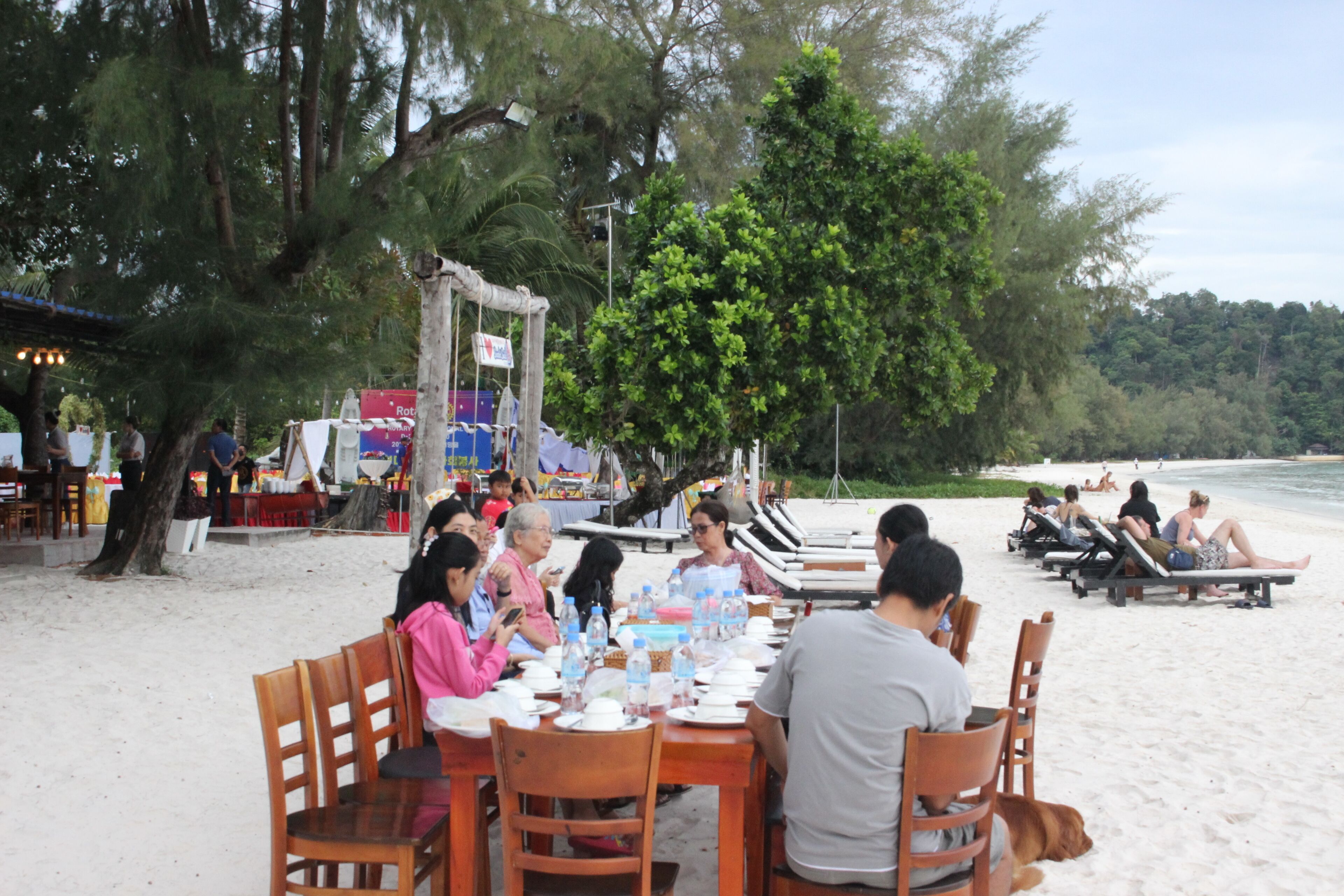 A beachside dining area with tables and chairs, overlooking the ocean.