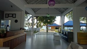 A spacious lobby with a reception desk, seating areas, and a view of the beach. - SCARLET SAILS VILLA (Koh Rong)