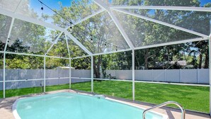 Una piscina con una escalera blanca y una valla de seguridad.