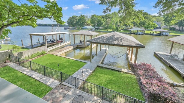 A lakeside property with a dock, covered seating areas, and a well-maintained lawn. - The Marlin House: Waterfront Escape with Dock, Outdoor Kitchen & Stunning Views! (Willis)