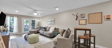 A spacious living room with a large sofa, a coffee table, and a dining area with a table and chairs.