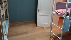 A room with a wooden bunk bed, a white door, and a blue wall. - Room-bed 14 in a 6-bed Mixed Dormitory r (Sintra)