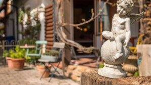 A garden statue on a wooden stump. - Room 'Kräutergärtle' with Private Terrace, Shared Garden and Wi-Fi (Immenstaad am Bodensee)