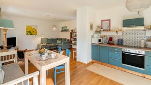 Een kleine keuken met een eethoek, een bank en een televisie.