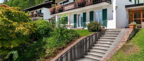 A two-story building with a balcony, a staircase, and a sign that reads 'Haus Erichendron.'