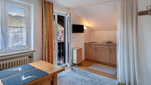 A kitchen with a window, a television, and a view of a mountain. - Studio Apartment 'Haus Latschenhang 3 Soiernblick' with Mountain View, Balcony and Wi-Fi (Mittenwald)