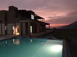 A modern house with a swimming pool at dusk. - Cieneguilla ECO House -Petfriendly - 2000m2 (Up to 28 persons) (Pachacamac)