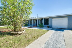 A modern two-story house with a garage, a well-maintained lawn, and a tree in the front yard. - Port Charlotte Vacation Rental w/ Heated Pool! (Port Charlotte)