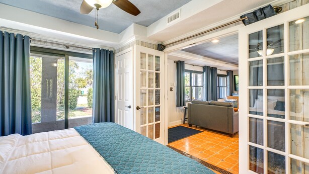 Ein Schlafzimmer mit Bett, Deckenventilator und Blick ins Freie.