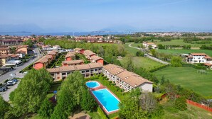 Ein Resort mit mehreren Gebäuden, einem Swimmingpool und Blick auf das Meer.