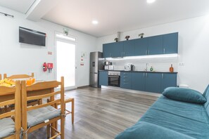 Una cocina moderna con armarios azules, horno empotrado y refrigerador.