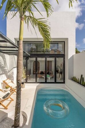 Una piscina al aire libre, sillones reclinables de piscina