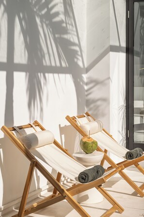 Una piscina al aire libre, sillones reclinables de piscina