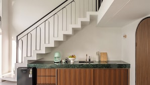Una cocina moderna con encimera de mármol, armarios de madera y refrigerador empotrado.