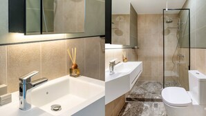 A modern bathroom with a white sink, a glass shower enclosure, and a toilet. - Exceptional Living Loft 704 (Athina)