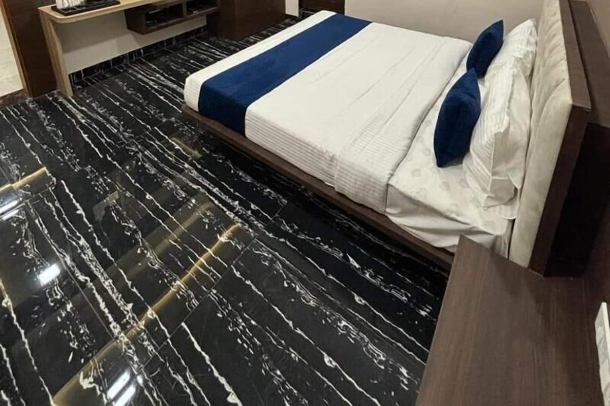 A modern hotel room with a bed, a TV, a wardrobe, and a ceiling fan.