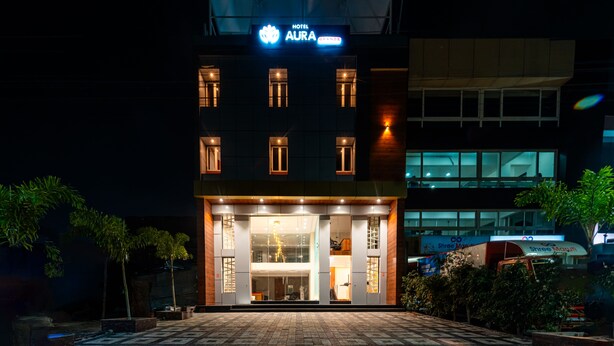 A hotel with a modern facade, illuminated signage, and a well-lit entrance.