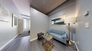 Relax in this stylish living area with a sofa, coffee table, and floor lamp, perfect for unwinding.