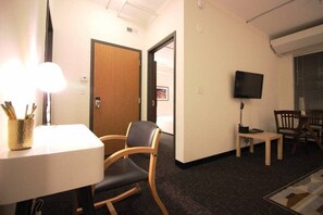 A hotel room with a desk, a chair, a television, and a door leading to another room. - Perfect One Bedroom Stay In Downtown Boston! (Boston)