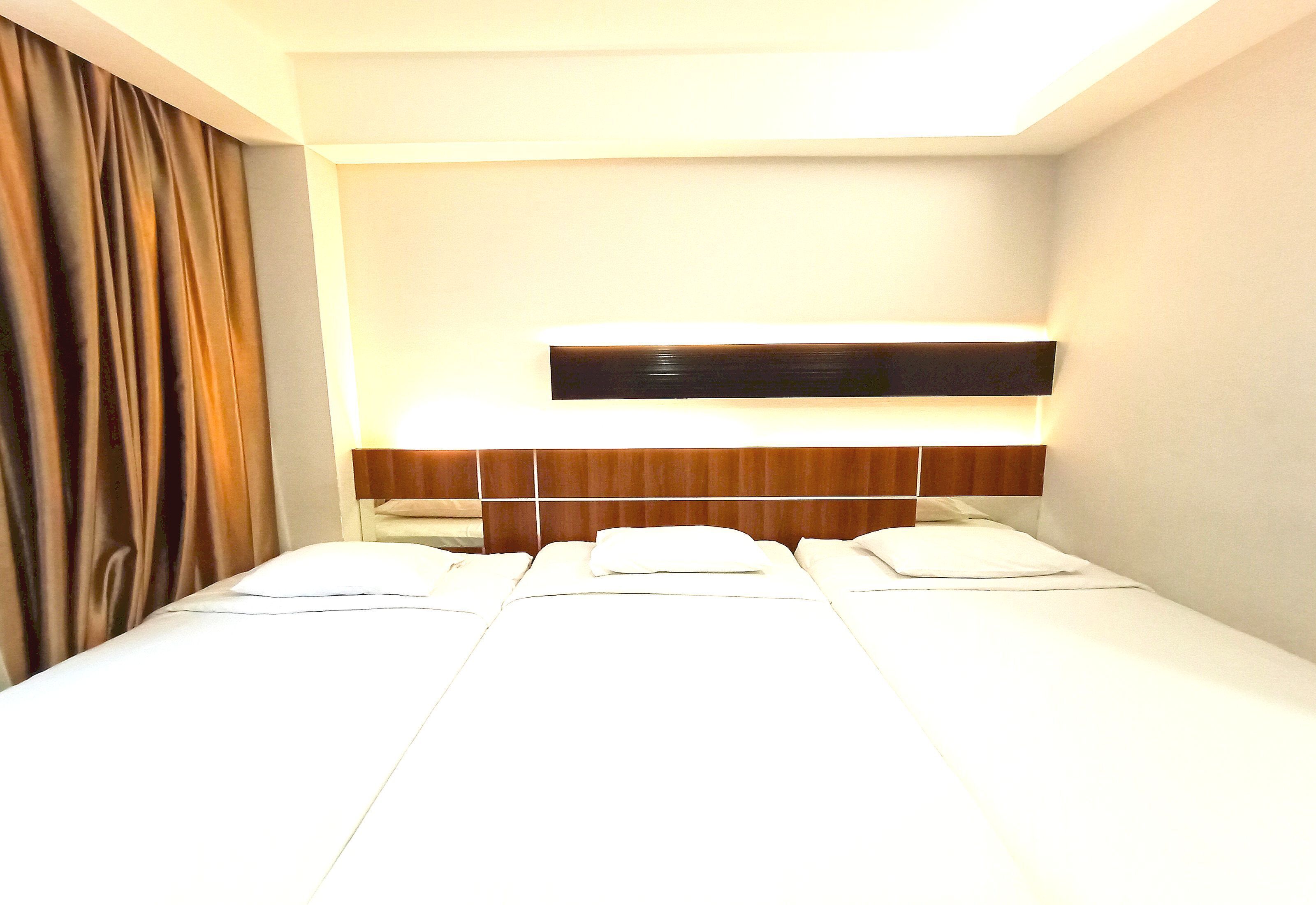 Ein Hotelzimmer mit Bett, Nachttisch und Kopfteil.