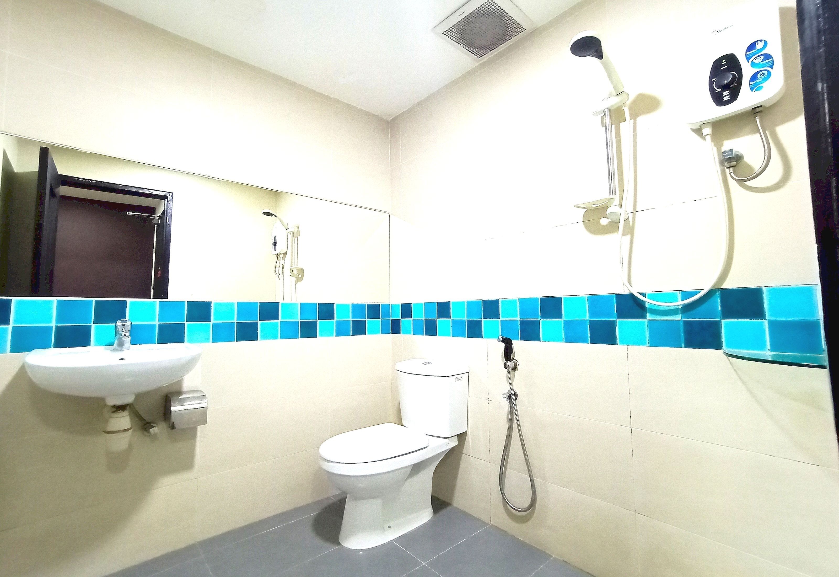 A bathroom with a toilet, sink, and shower.
