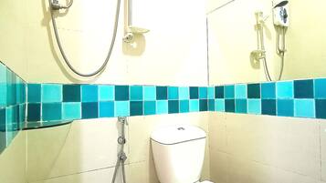 A bathroom with a toilet, a shower, and a bidet.