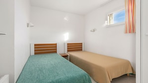 A small, single-bed room with a window, a radiator, and a curtain. - Apartment with a balcony, 300 meters from the beach (Agde)