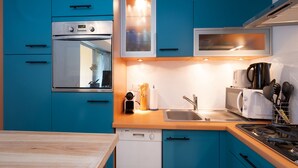 Une cuisine moderne avec des meubles bleus, un lave-vaisselle Bosch, un four à micro-ondes et une cuisinière.