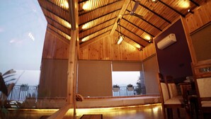 Amplio espacio interior con techo alto, vigas de madera y un escenario.
