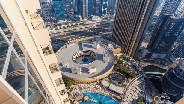 A high-rise hotel with a circular rooftop pool, a central courtyard, and a view of the cityscape. - Stunning Studio JW Marriott Marina (Dubai)