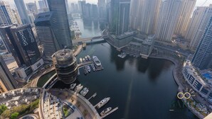 A high-rise urban area with a marina, modern skyscrapers, and a distinctive circular building. - Stunning Studio JW Marriott Marina (Dubai)