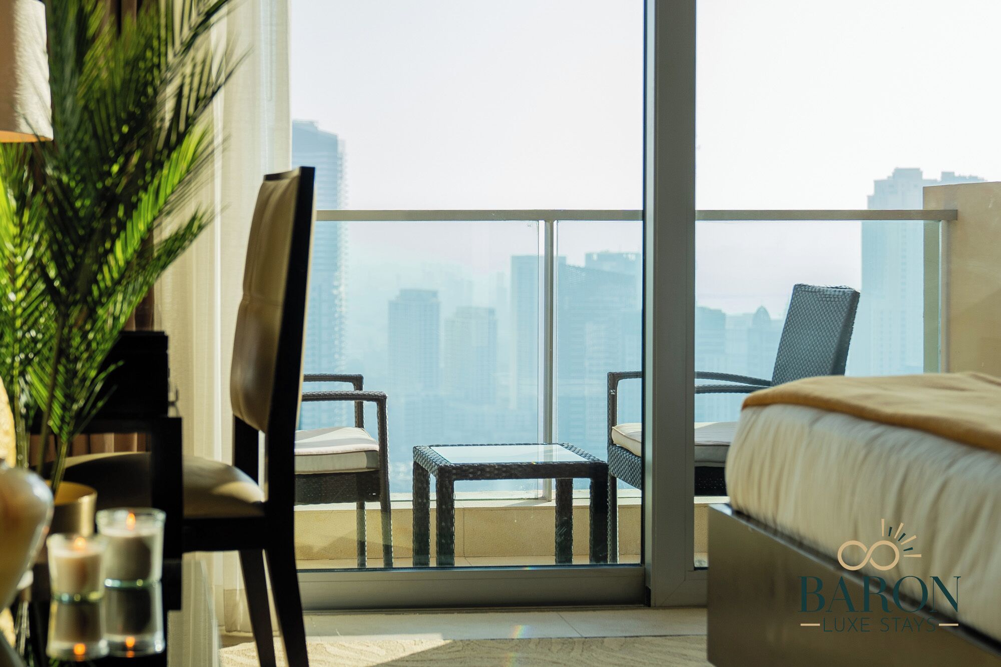 A modern hotel room with a large window, a bed, a chair, and a small table.