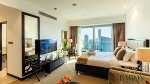 A hotel room with a bed, a TV, a desk, and a view of the city. - Stunning Studio JW Marriott Marina (Dubai)