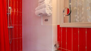 A bathroom with a red and white color scheme, including a shower, a sink, and a mirror.