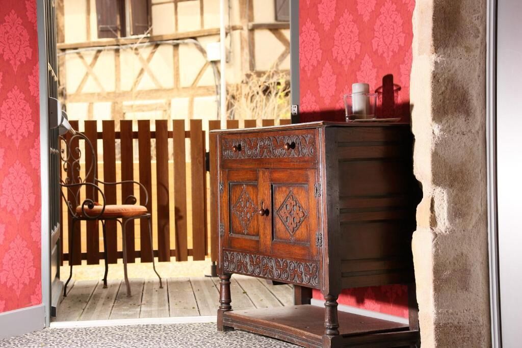 Un buffet en bois orné de sculptures complexes, une chaise et une clôture en bois en arrière-plan.