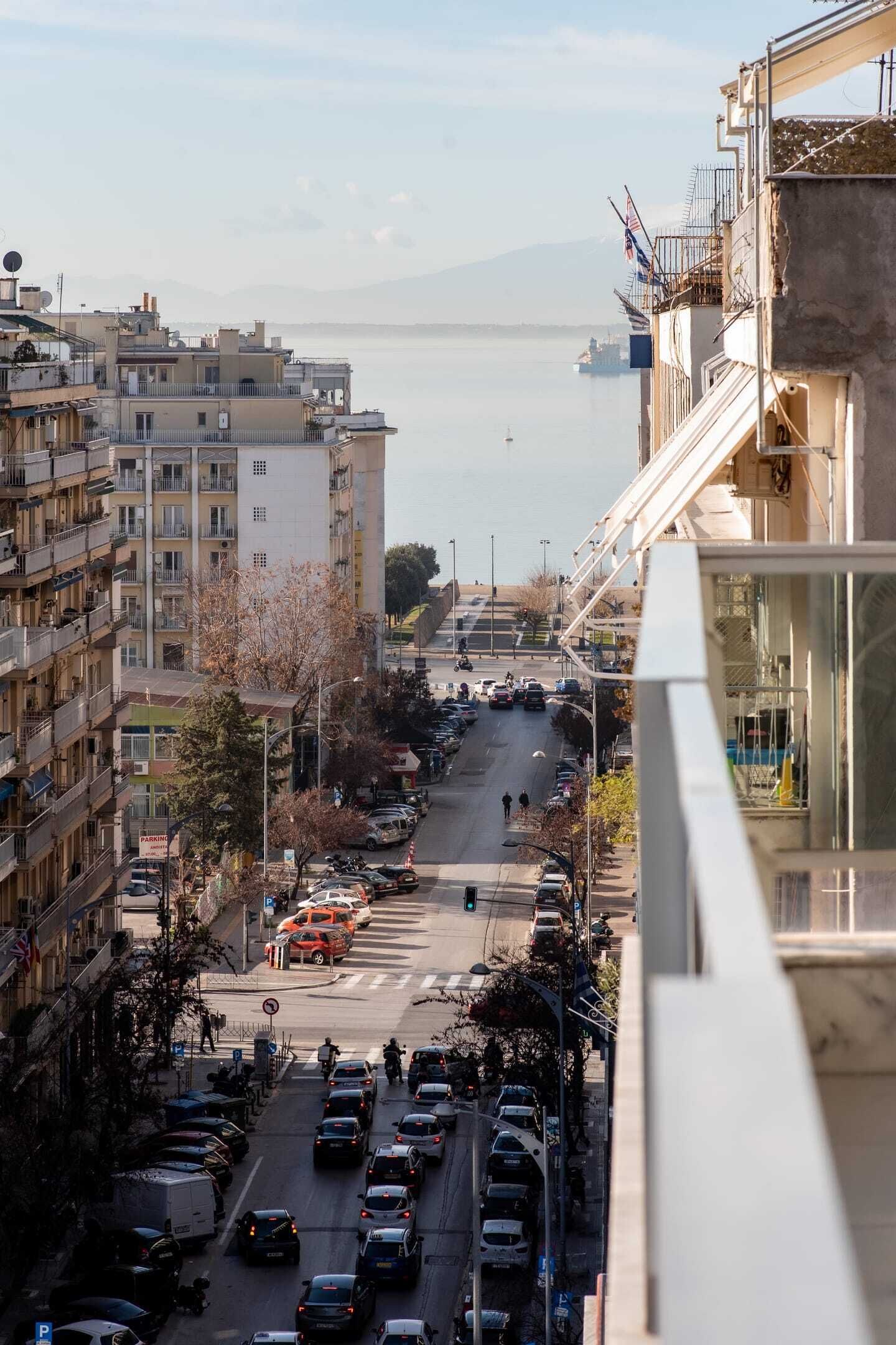 Une rue de la ville, avec des bâtiments d’un côté et une étendue d’eau de l’autre.