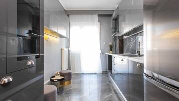 A modern kitchen with dark cabinetry, a central island, and a view to the dining area.
