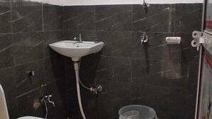 Un baño pequeño con inodoro, lavamanos y ducha.