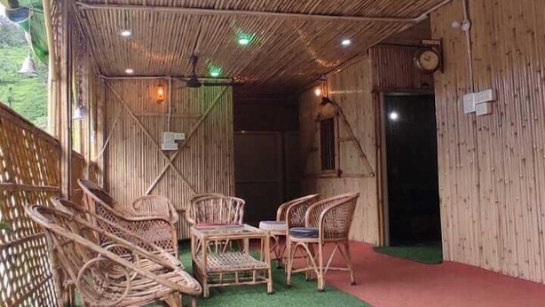 Un espacio interior con paredes de bambú, ventiladores de techo y muebles de mimbre.